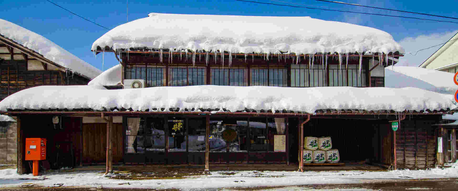 屋根に雪の積もった君の井酒蔵