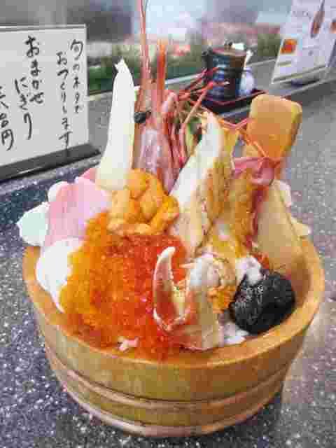 ウニ、いくら、トビコ、マグロ、有頭海老、アナゴが山のように高くそびえるような海鮮丼の画像