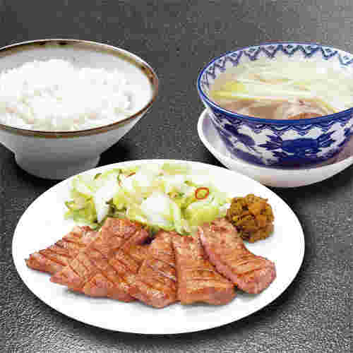 レア気味に焼かれた、切り身の入った柔らかそうな厚切りの牛タンの画像