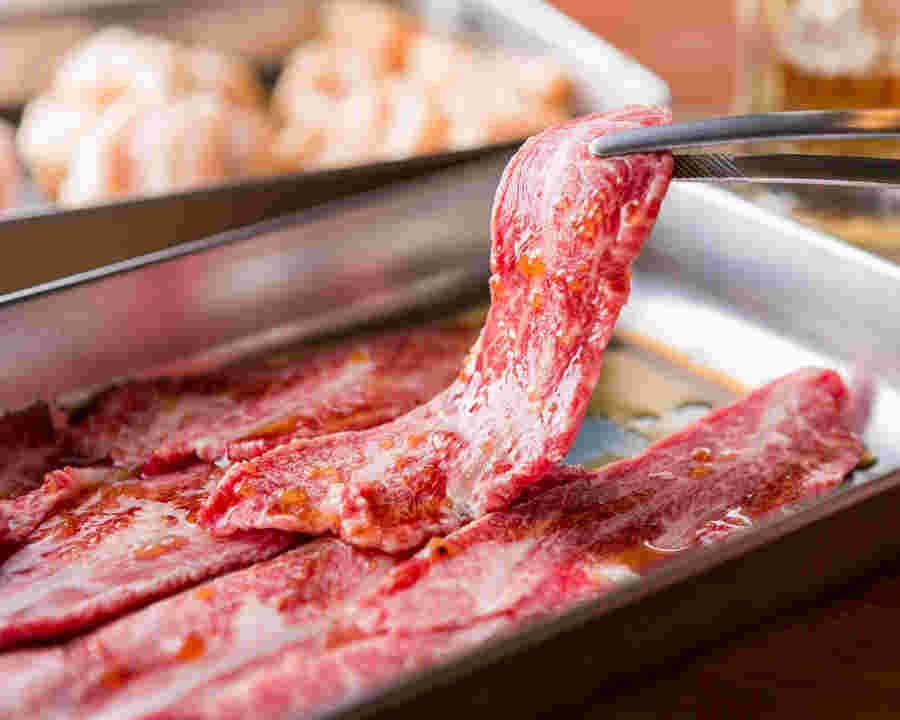 さしが入った牛肉にタレがたっぷりしみ込んだ美味しそうな画像