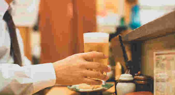 カウンター席でビールを持っている人