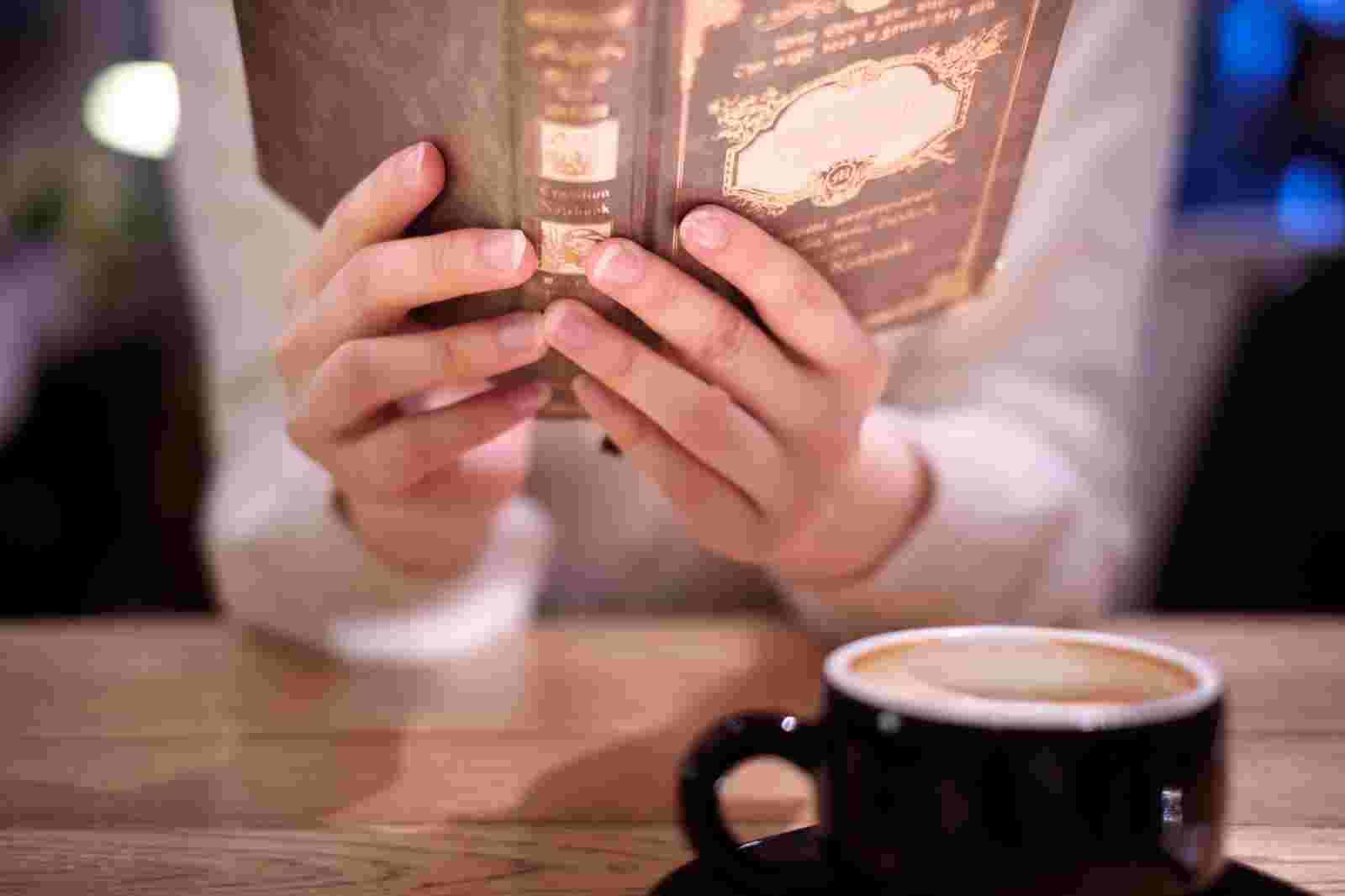 カフェで一人で本を読む女性