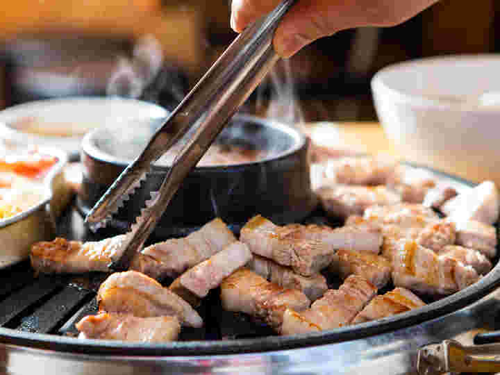 丸い専用の鉄板で焼かれる美味しそうなサムギョプサル