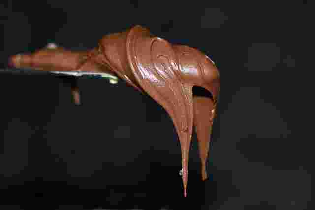 ソフトクリームのチョコレートのようにドロドロしているけれども固まっているような質感のチョコレートがヘラの上に乗せられていて、落ちそうで落ちない状態になっています。牛乳やバターなど織り交ぜられたように薄い茶色でつや感があります。一口舐めると口の中で甘くてカカオの香りがしそうです。