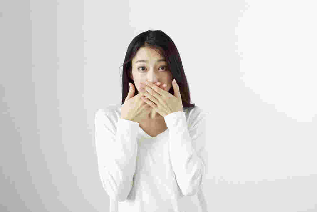 口を押さえる女性