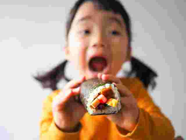 大きな口で恵方巻きを食べようとする女の子