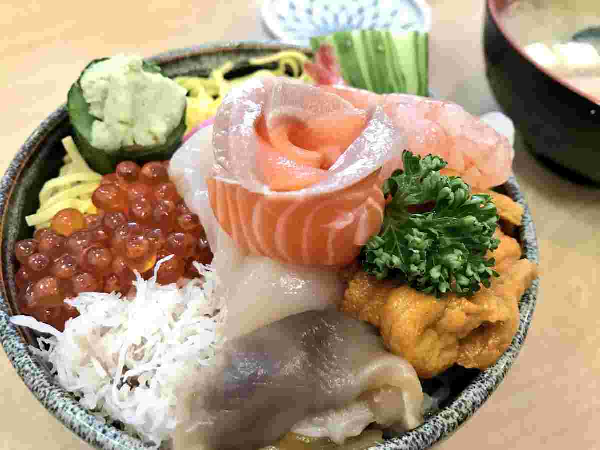 サーモンがバラの花のように中央に盛り付けられた豪華な海鮮丼