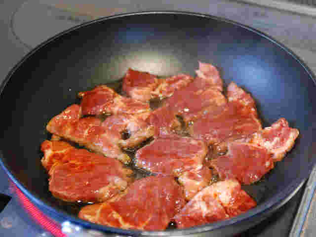 フライパンで焼肉を焼いている様子