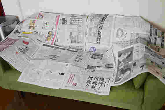 ソファーに新聞紙をかけている