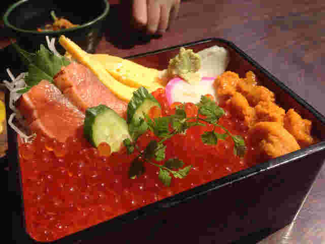 大粒のうに、沢山のイクラ、鮭や卵焼きが乗っている海鮮丼の画像
