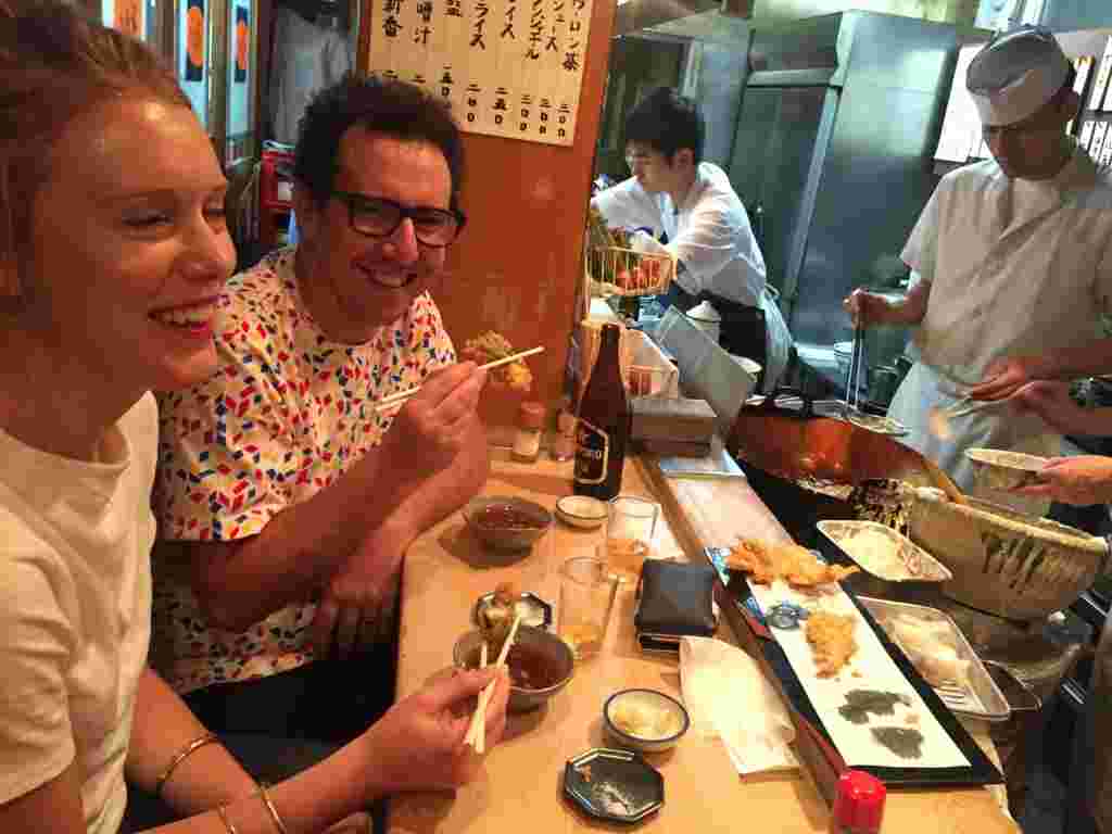 上手に箸を使って天ぷらを食べる外国人観光客