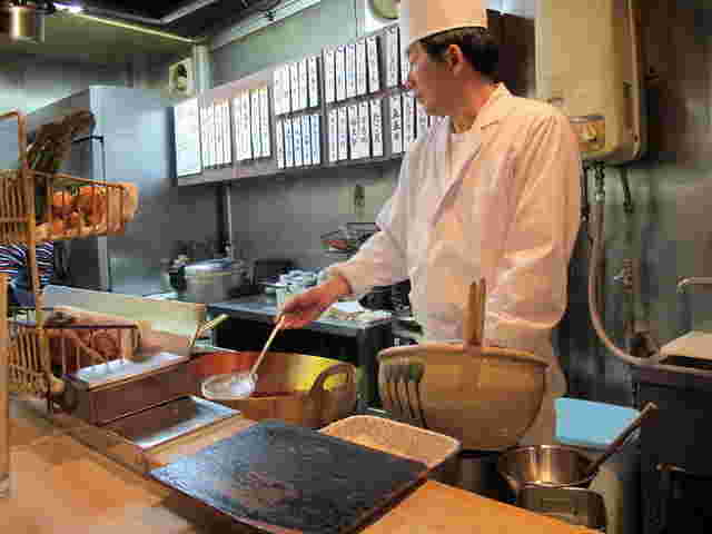 天すけ店内天ぷらを揚げている