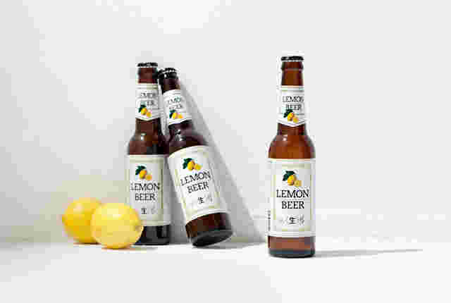 瓶のレモンビールと転がったレモン