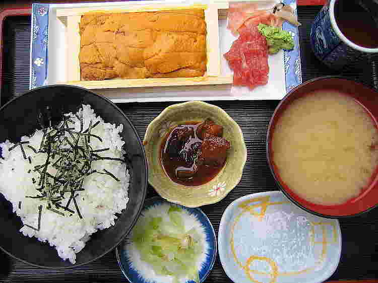 ご飯に魚の煮つけ、みそ汁に箱うにとマグロの中落ち等の定食の画像