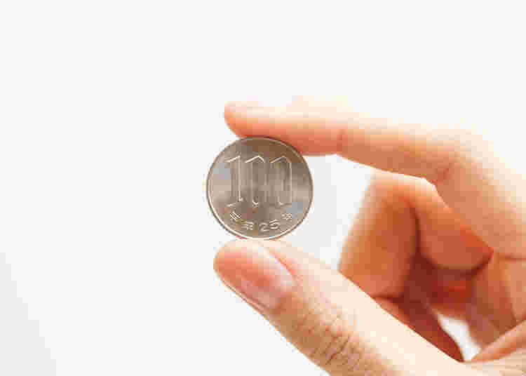 100円玉を持つ手