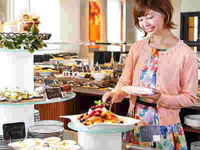 朝食ビュッフェを楽しむ女性