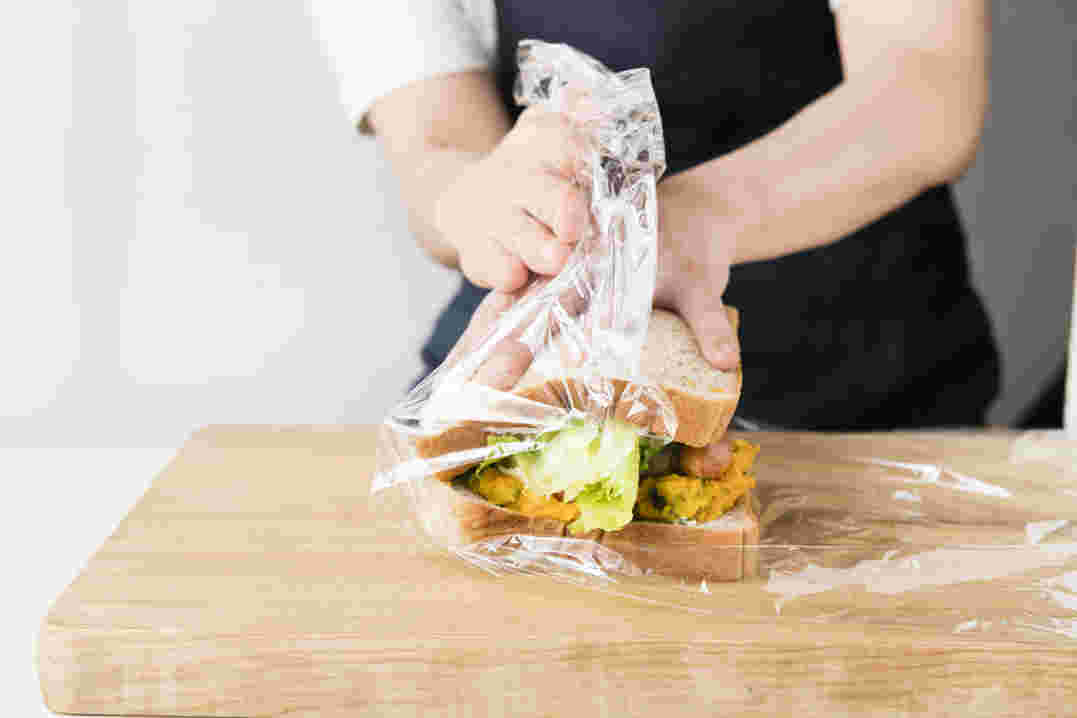 ラップでサンドイッチを包んでいるところ