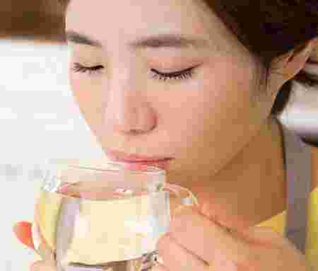 白湯を冷ましながら飲む女性