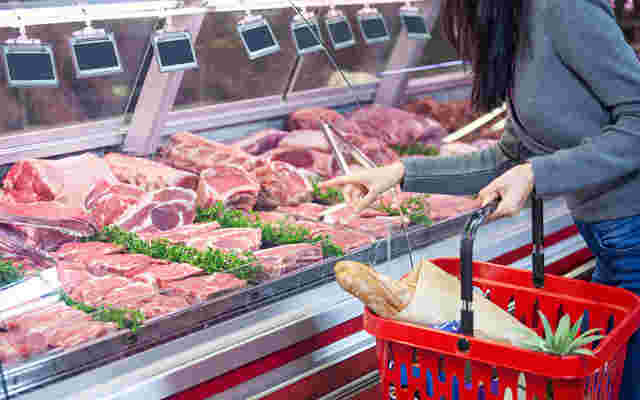 販売されている肉を選ぶ女性