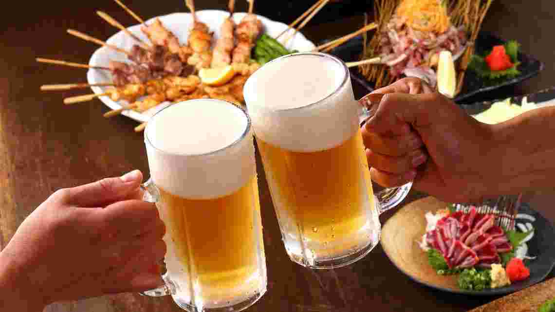 ビールのジョッキで乾杯している居酒屋さんの画像