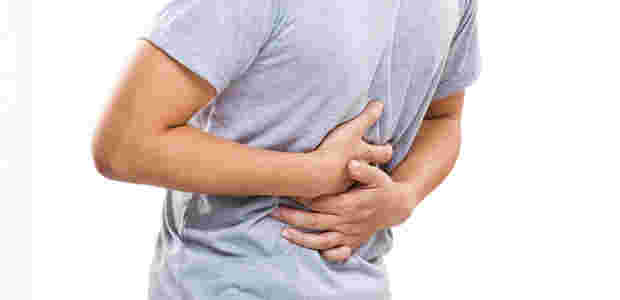 腹痛を感じてお腹を押さえている男性