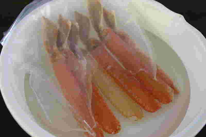 ビニールに入ってボウルに入ったカニの足数本