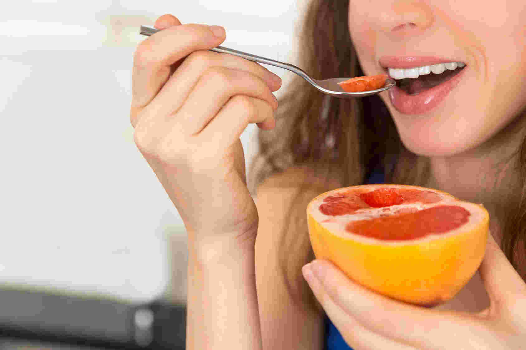 グレープフルーツを食べる女性