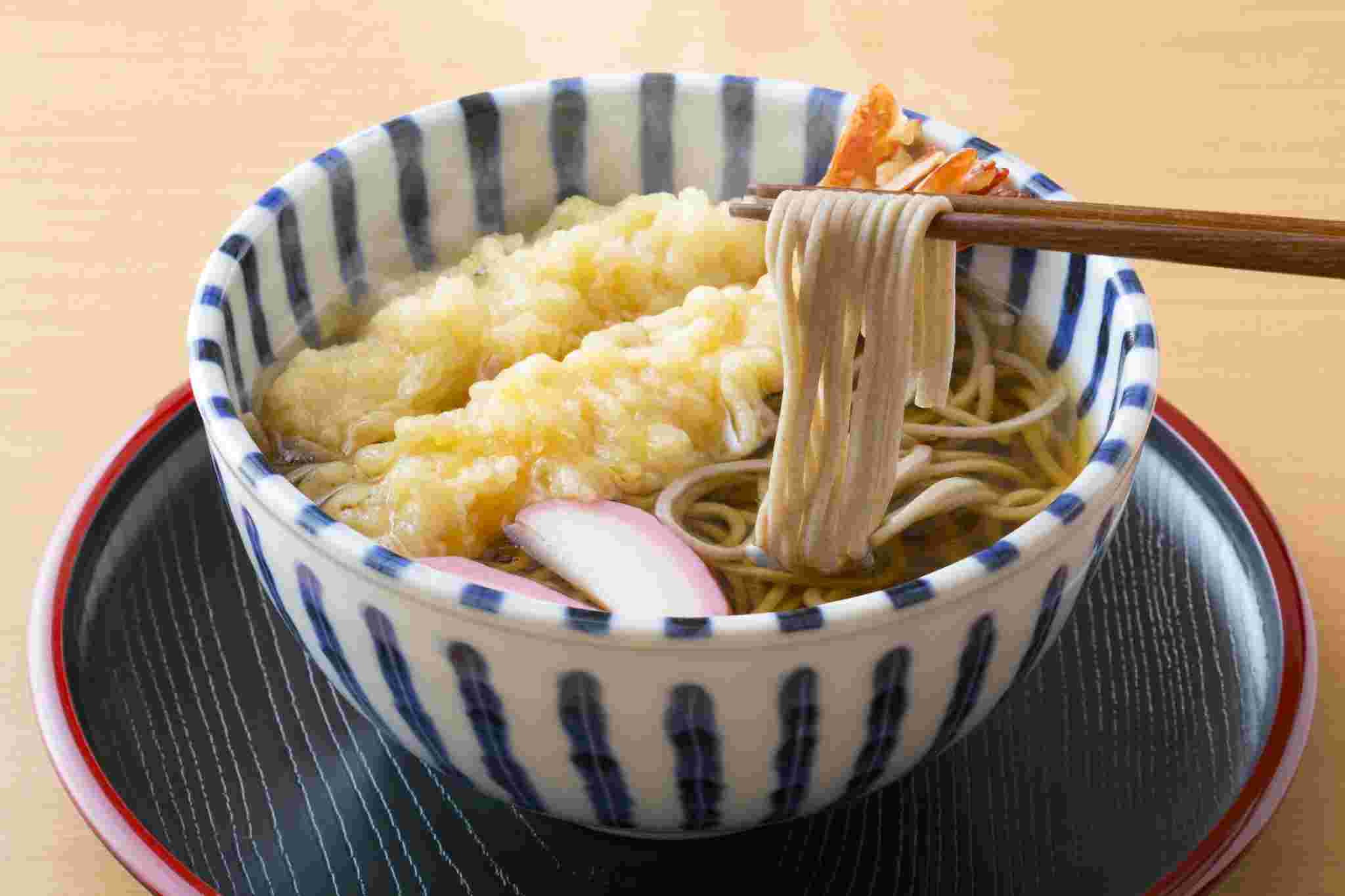 エビ天の入った蕎麦をはしで持ち上げる