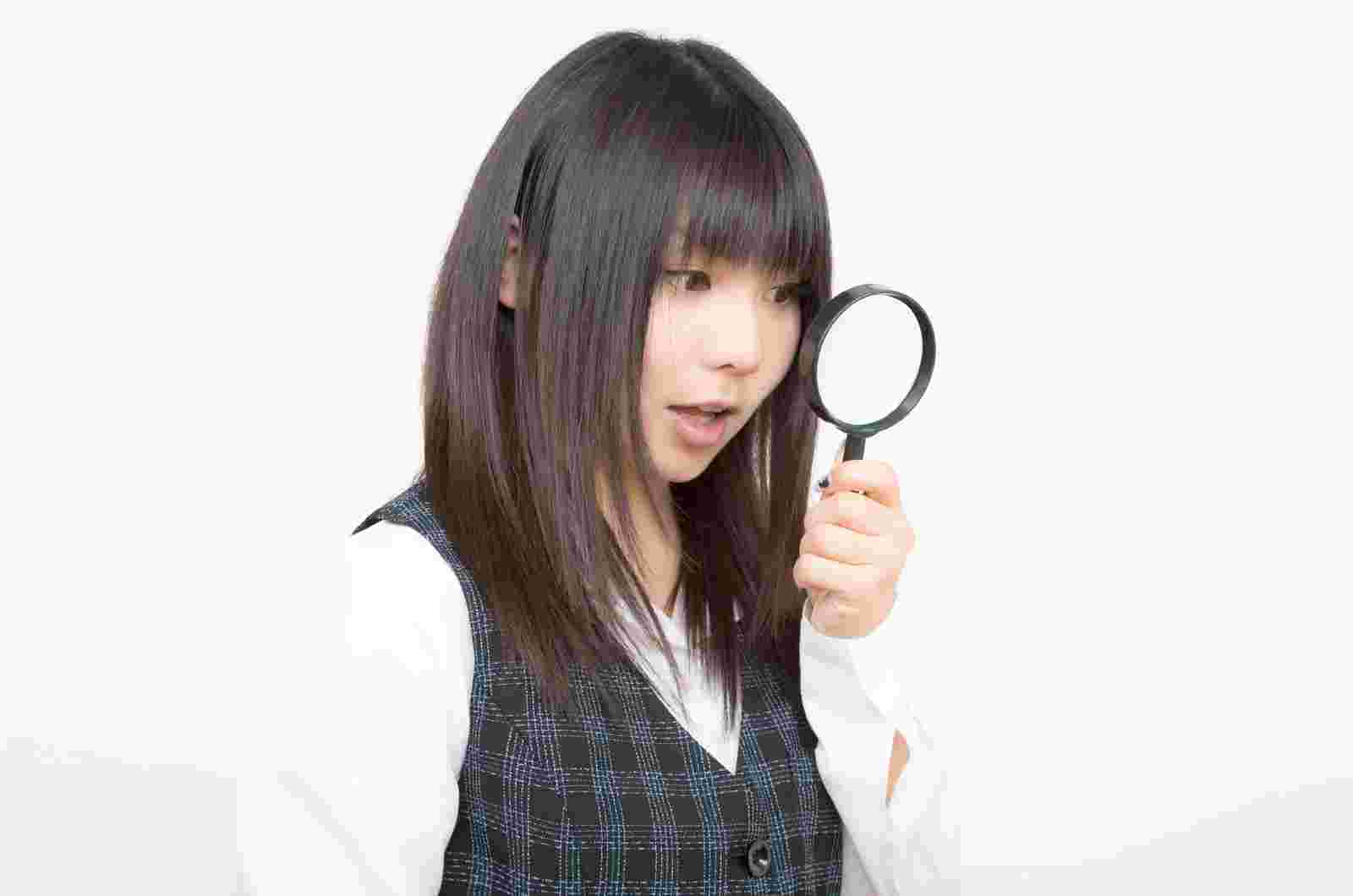 虫眼鏡で覗く女性