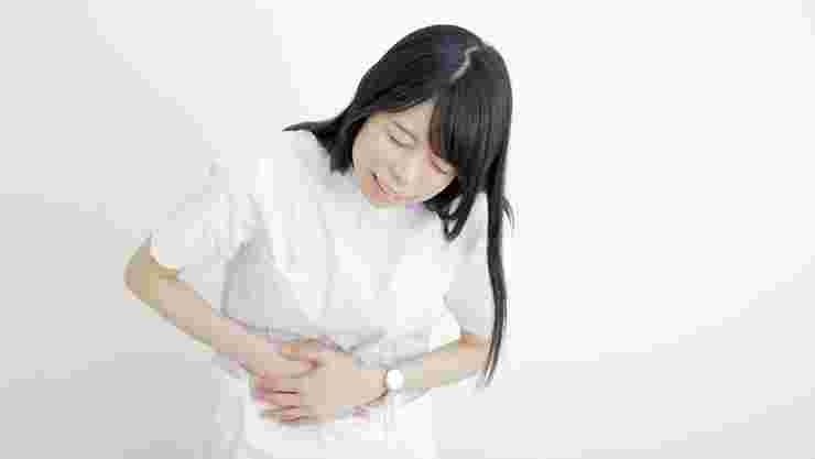 下痢の痛みでお腹をおさえる女性