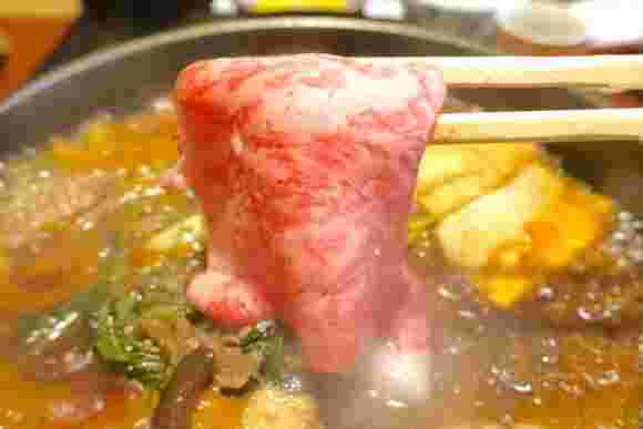 あさりのすき焼き、牛肉を鍋に入れるところ