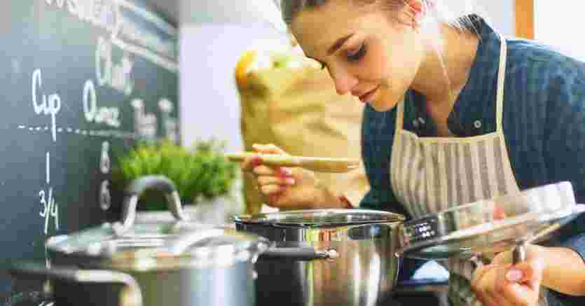 女性が料理の味見をしているイメージ図