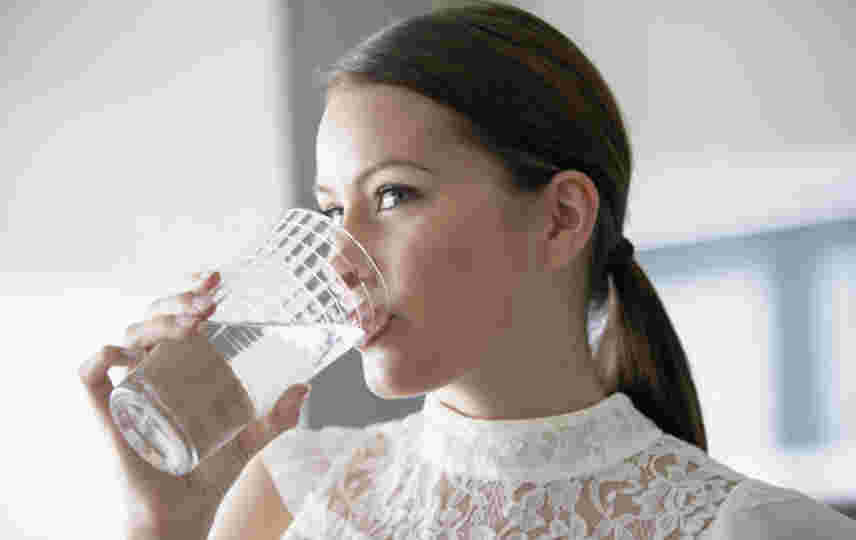 朝、炭酸水を飲む女性