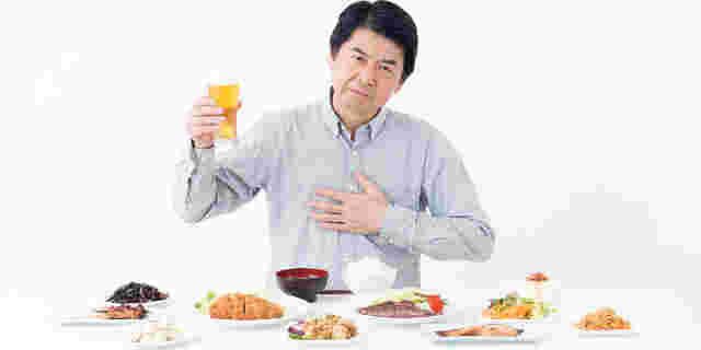 食べすぎで胃の調子が悪い男性