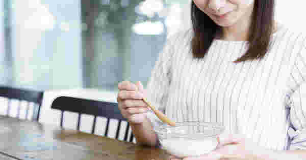 ヨーグルトを食べている女性