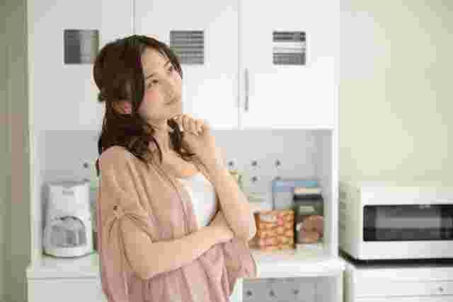 キッチンで悩む女性