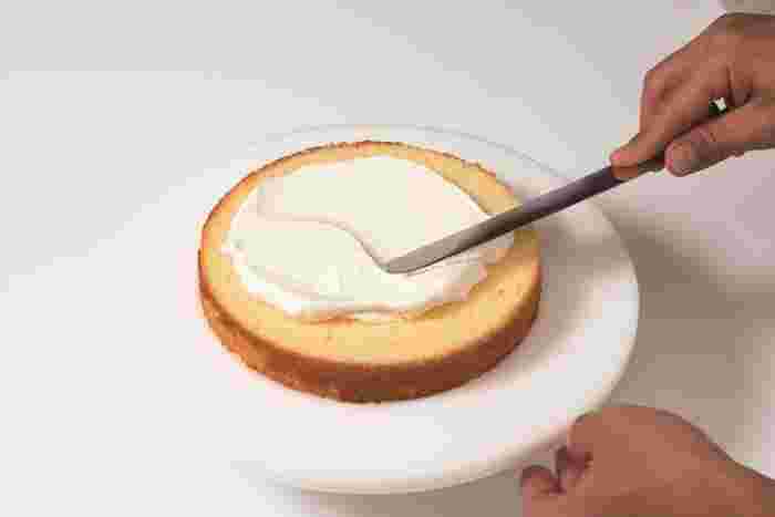 スポンジに生クリームをたっぷり塗っているところ