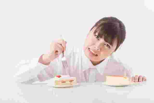 ケーキを食べるか迷う女性