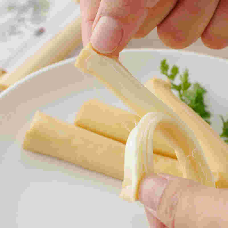 さけるチーズを裂いている