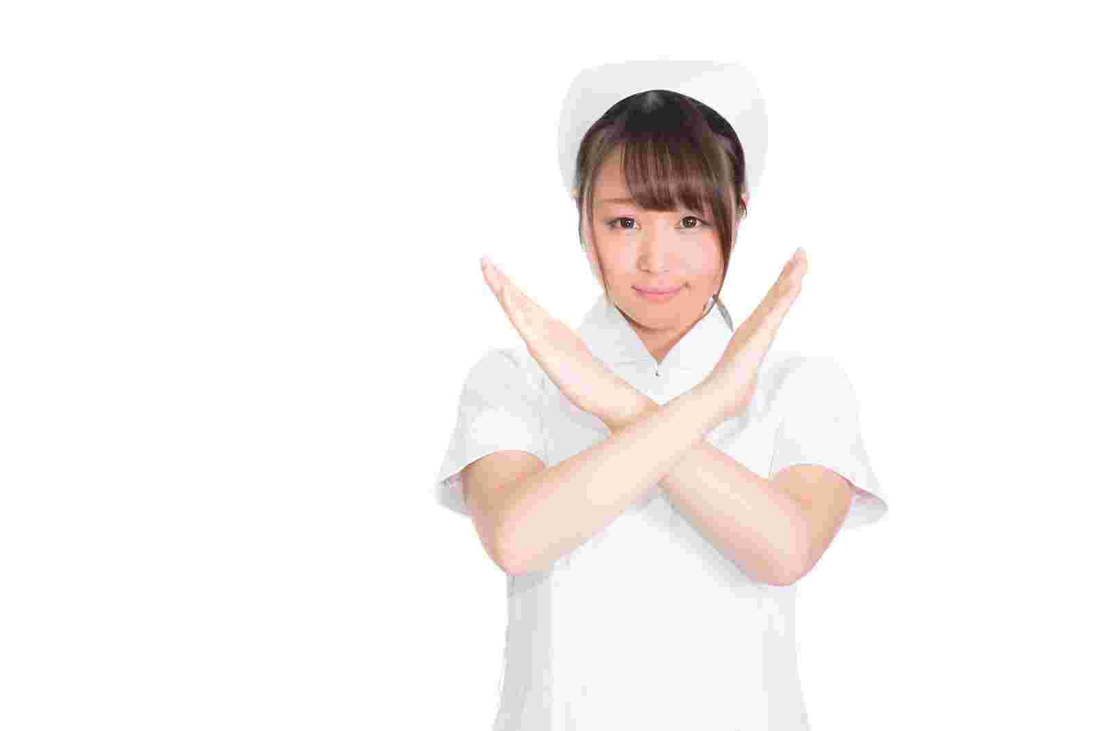 胸の前でバツ印を作る女性