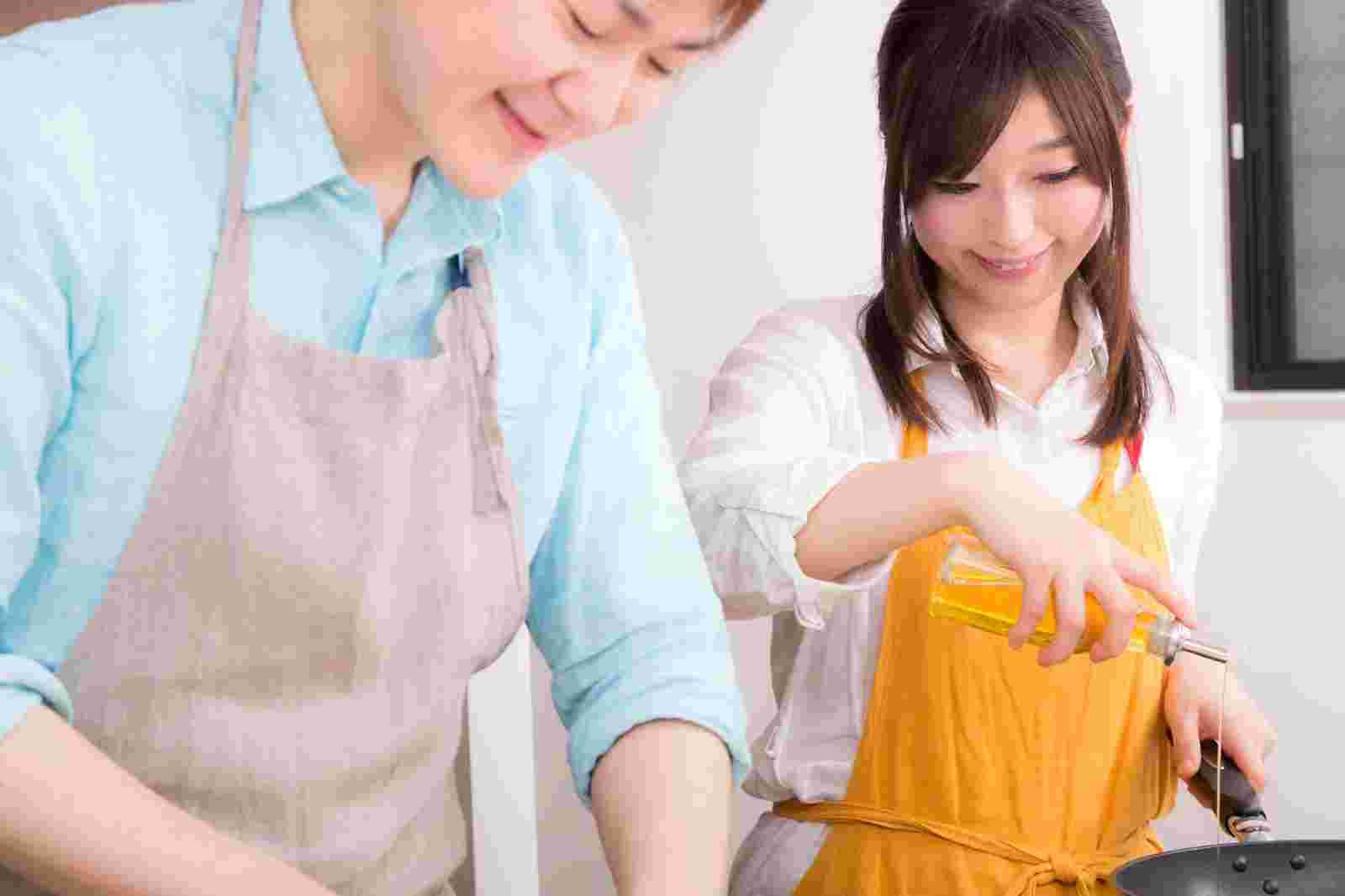 楽しく料理をする男女フリー画像