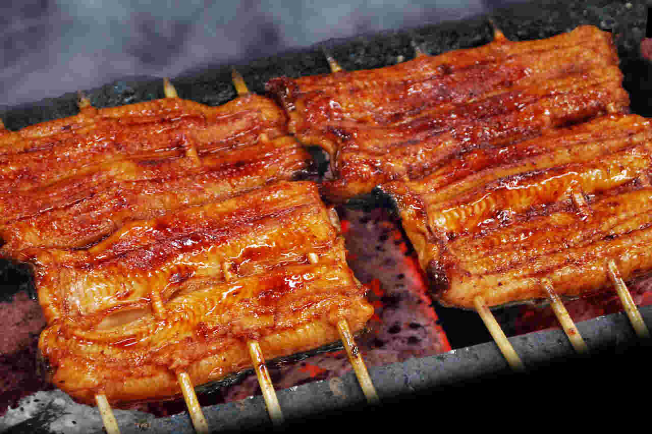 串に刺して炭火で焼かれているうなぎの蒲焼き