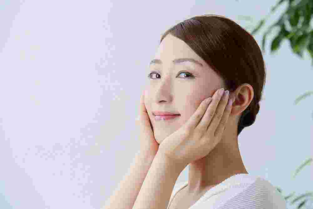 頬に手をあてる笑顔の女性