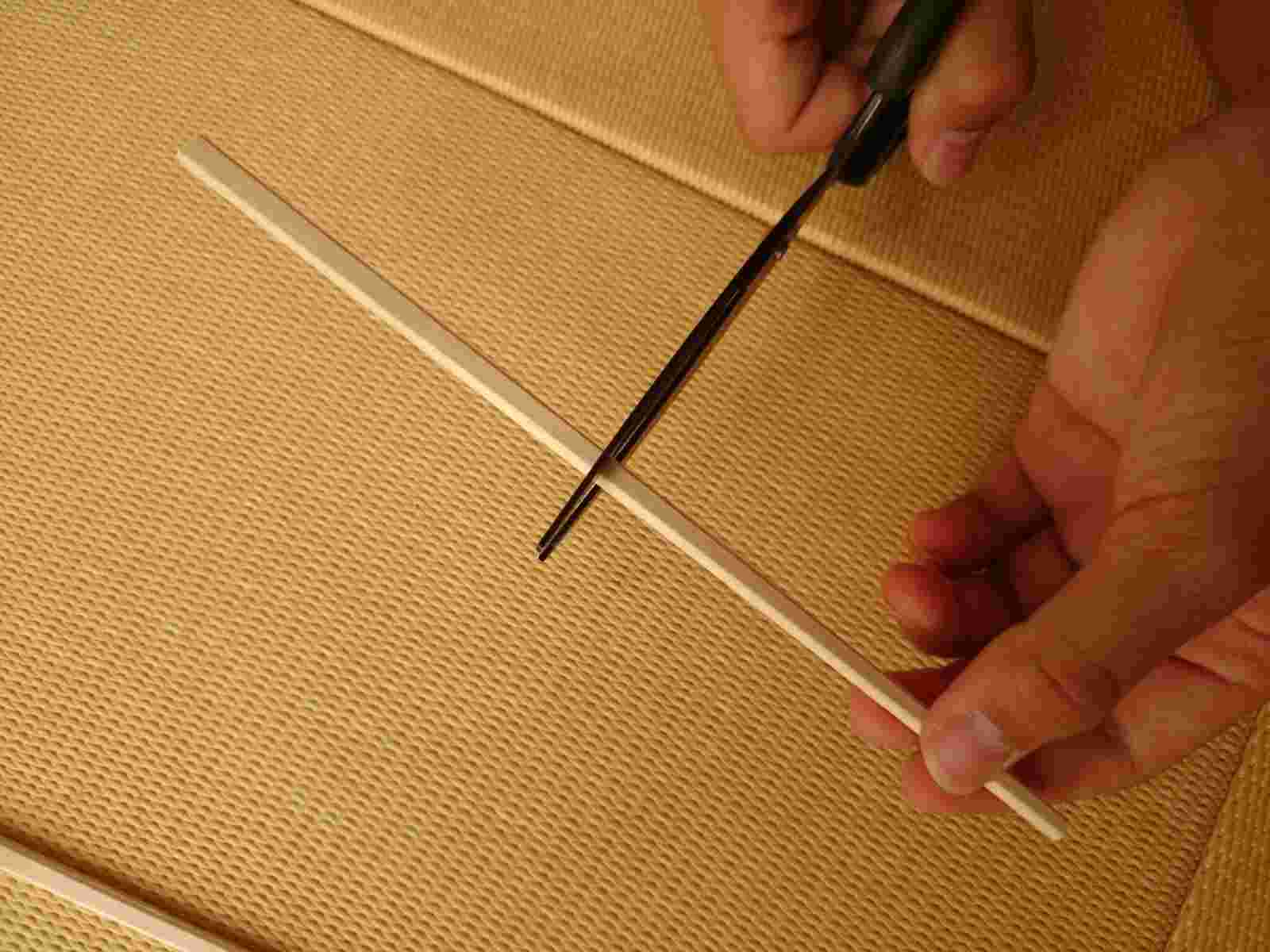 餅の大きさより短めに割り箸をハサミなどで切っているところ