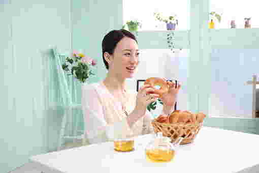歯ごたえがあるベーグルを食べる女性