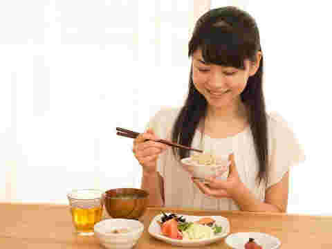 笑顔でご飯を食べている女性