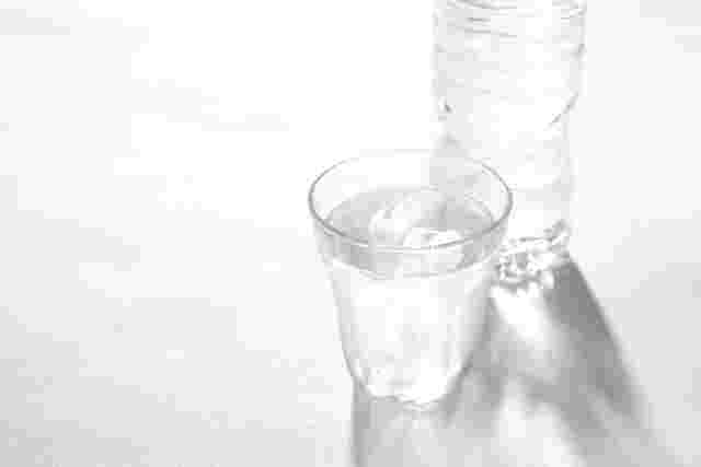 水の入ったペットボトルと水入れたコップ