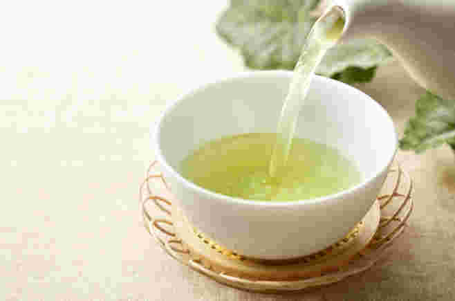 湯飲みに緑茶を入れている