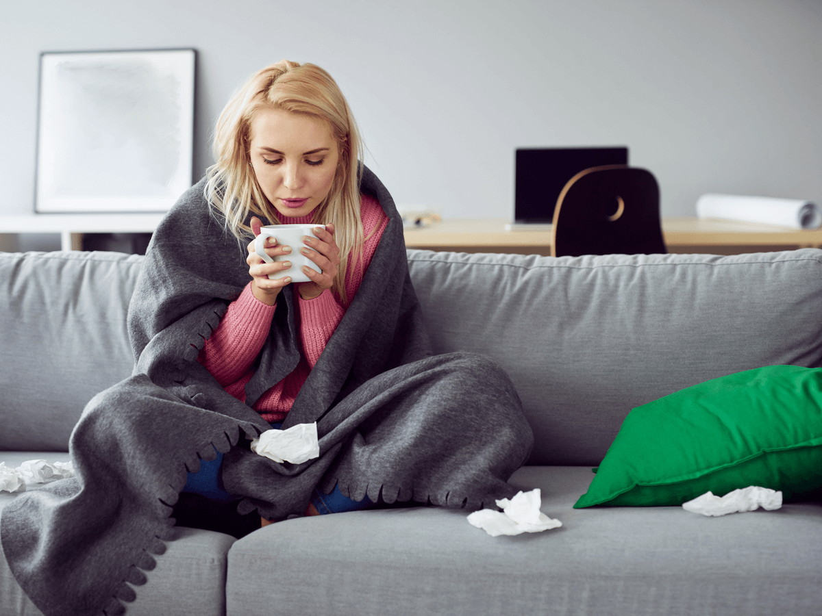 ソファの上でお茶を飲んでいる女性