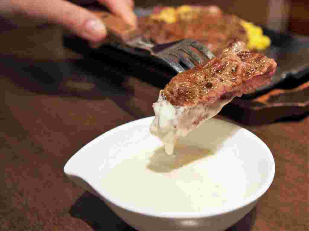 ブルーチーズソースディップでステーキをつけて食べる